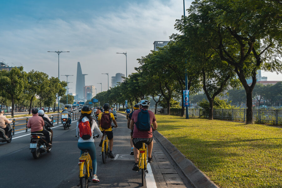 Travelers cycling along a tree-lined street during a one day Ho Chi Minh City itinerary-Jackfruit 