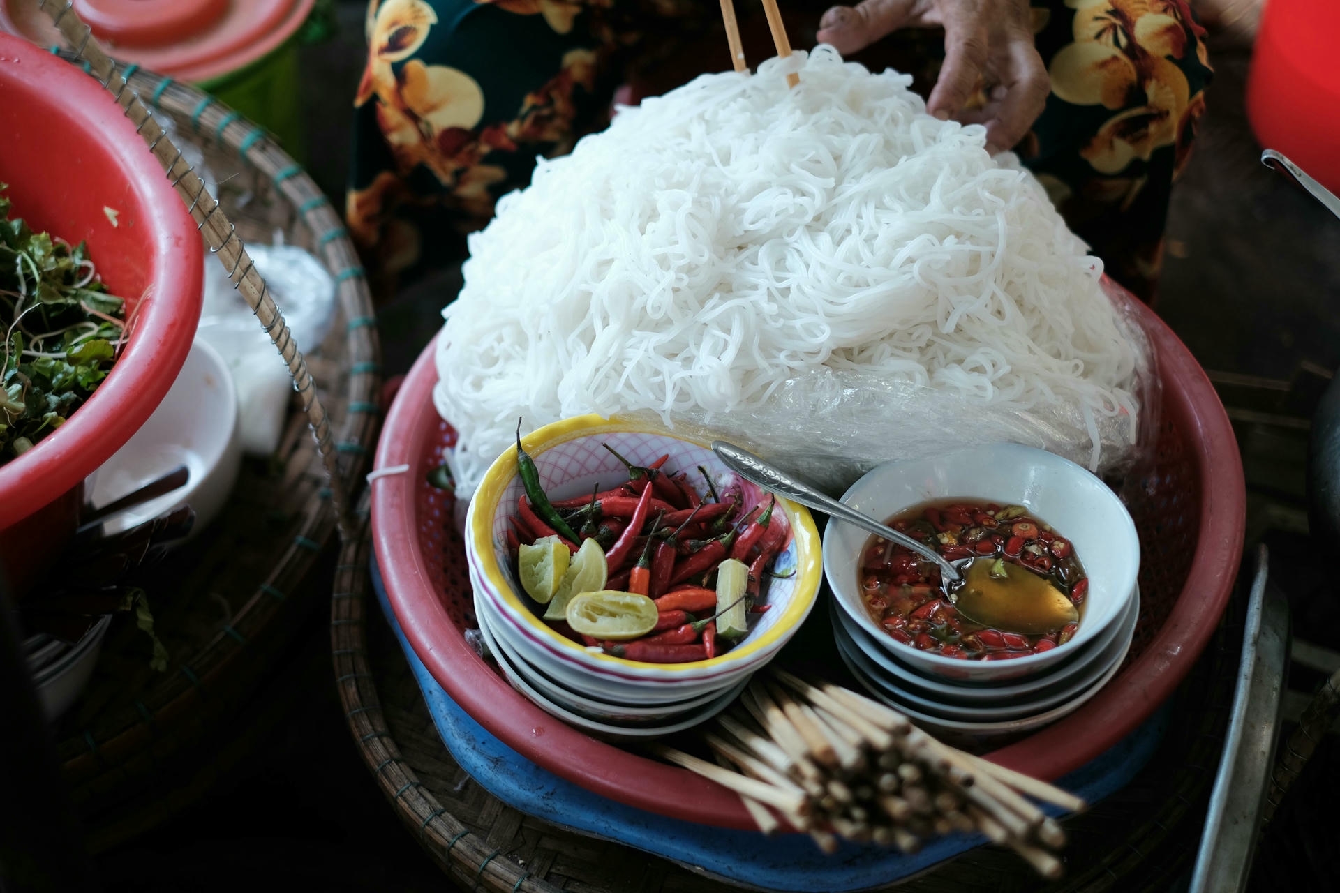 Spicy Hue-style noodle dish served with white noodles and fresh chili peppers, showcasing the bold and fiery flavors of Central Vietnam cuisine