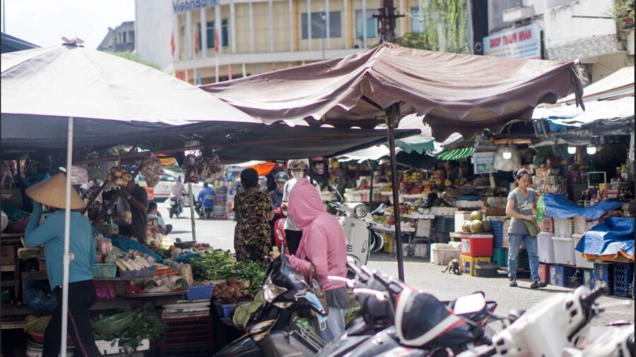 A bustling market in Saigon. Is hanoi bigger than saigon ?