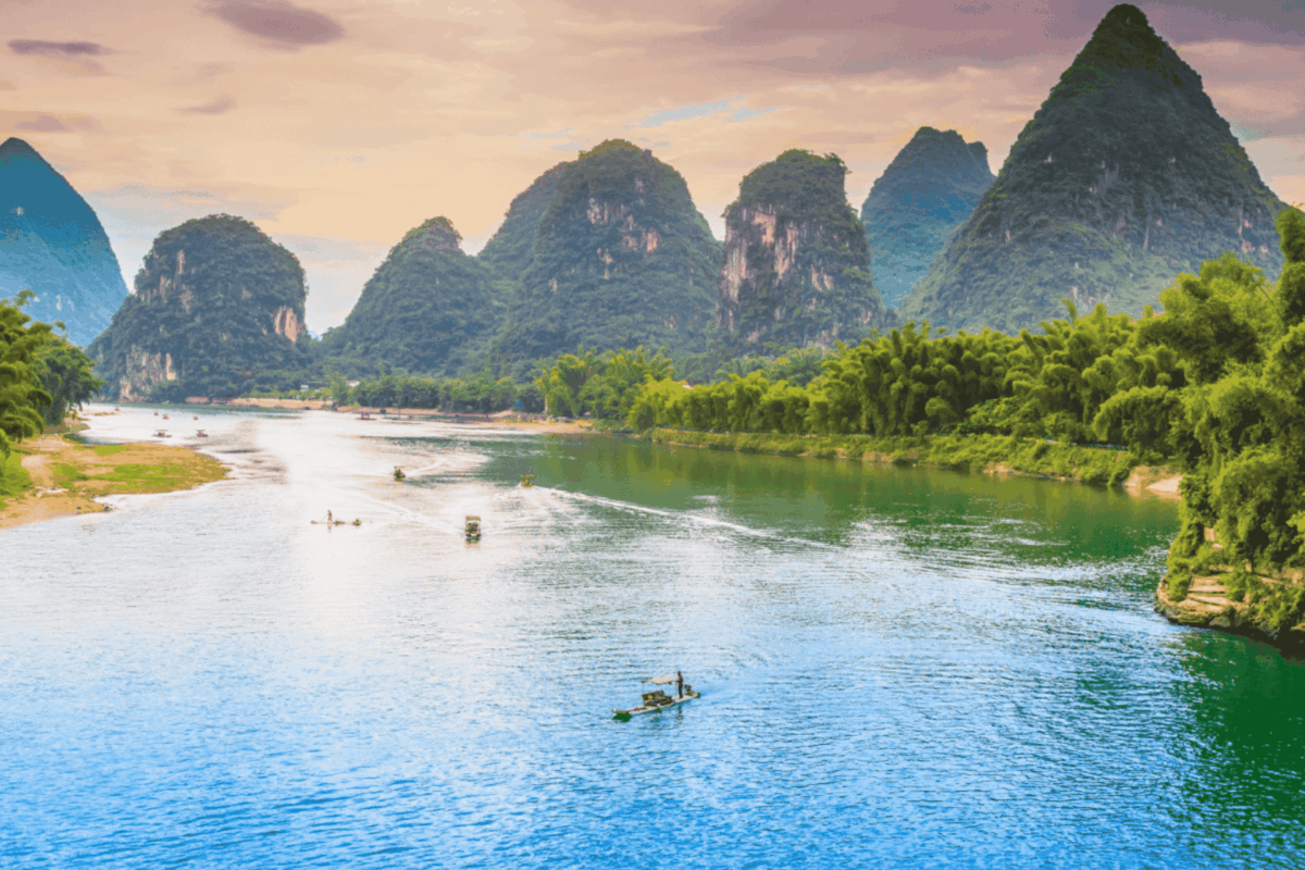 Serene river scene surrounded by towering limestone karsts on the route from Hanoi to Ninhbinh.