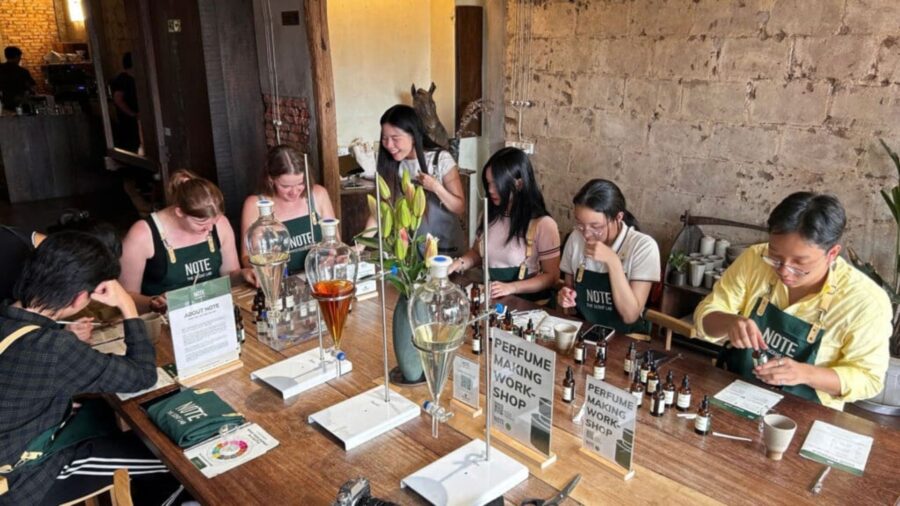 Travelers sit around a wooden table and test different scents during a perfume-making workshop, one of the most popular craft workshops in Ho Chi Minh City.
