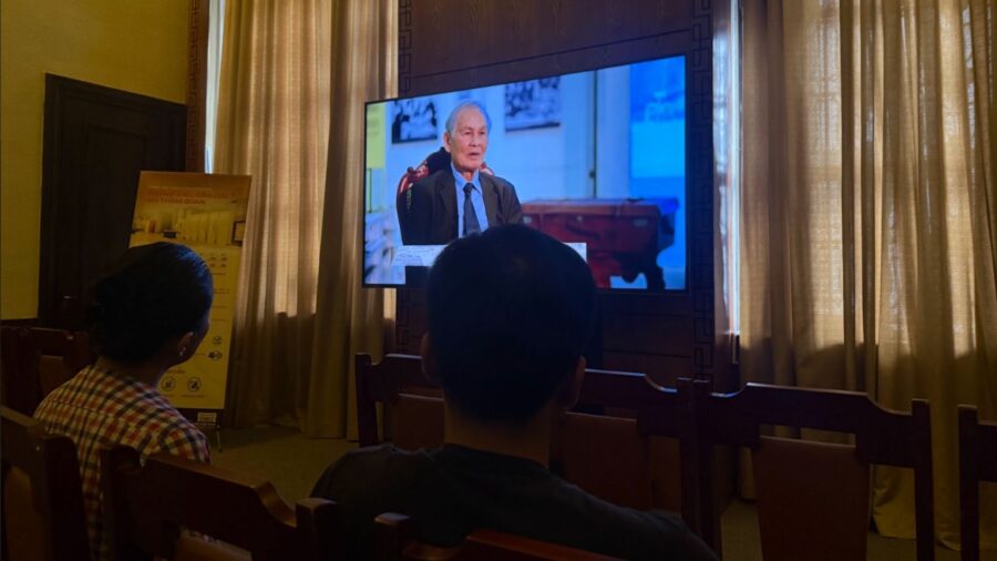 Visitors sitting in a gallery room and watching a video presentation at the Vietnamese currency exhibition in Ho Chi Minh City.