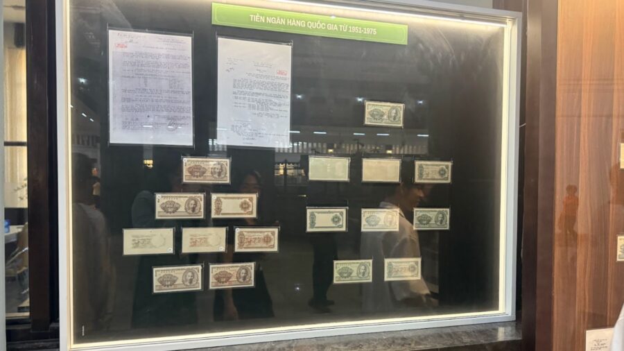 A glass display case showing State Bank of Vietnam notes from 1951 to 1975 at the Vietnamese currency exhibition.