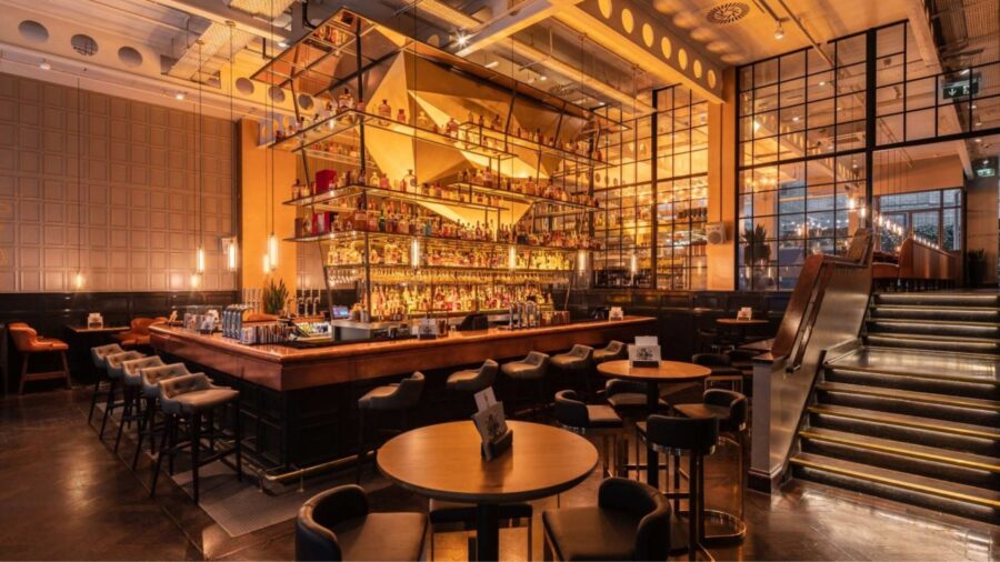 Elegant interior of The Alchemist Cocktail Bar in Hanoi with warm lighting and a central bar counter