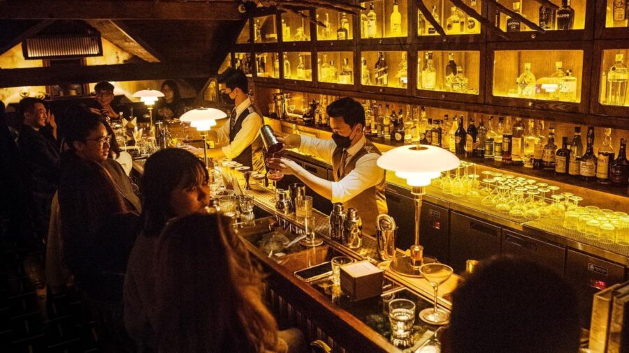 Guests sitting at the bar inside The Haflington, one of the best cocktail bars in Hanoi