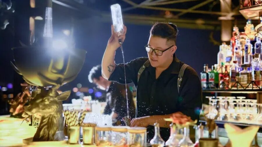 A bartender preparing and presenting a cocktail