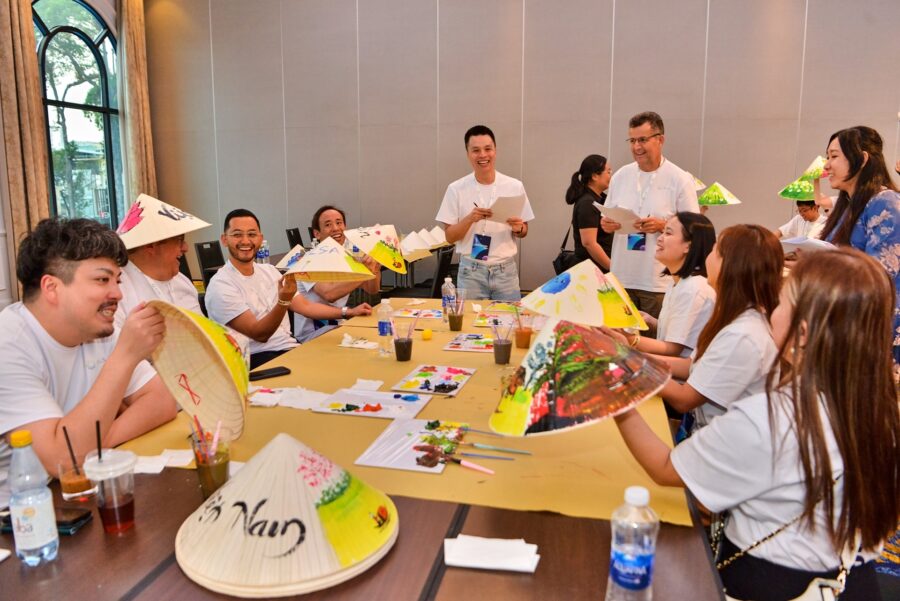 Corporate team bonding activities during a conical hat painting workshop focused on creativity and collaboration.