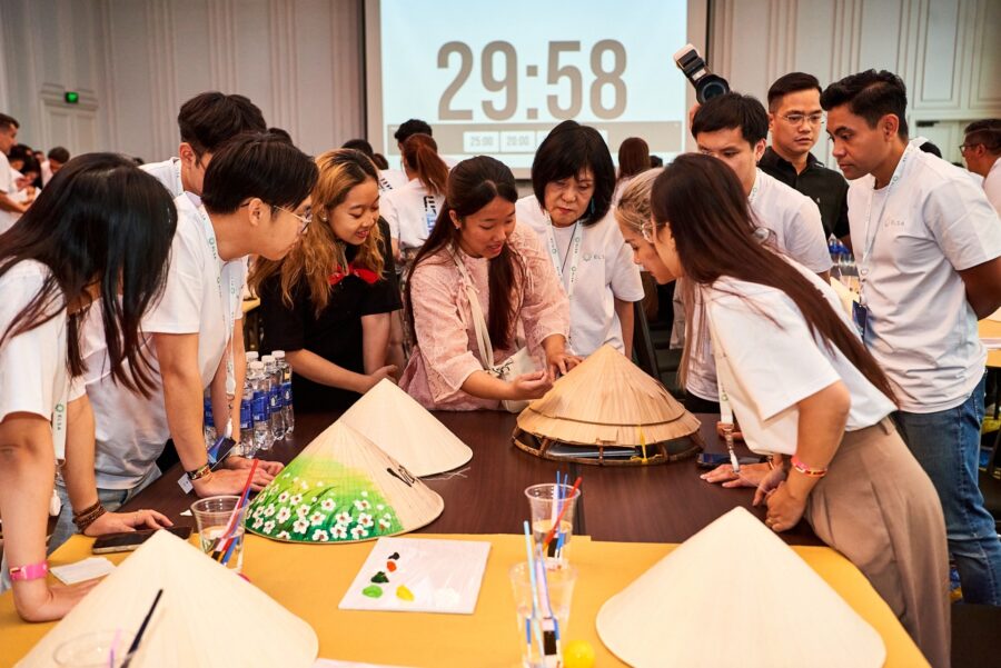 Corporate team participating in a creative workshop decorating conical hats during team bonding activities.