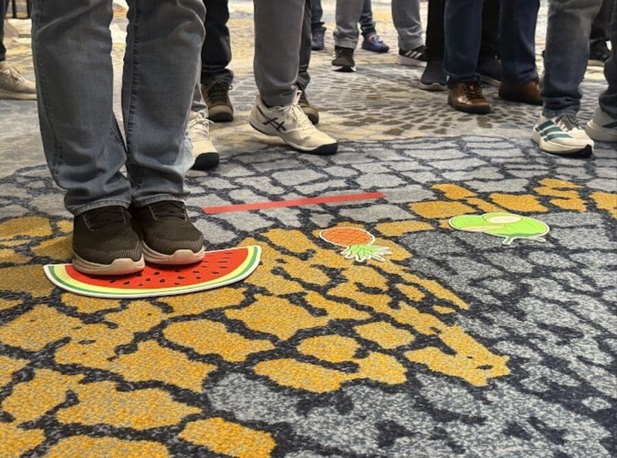 Corporate team bonding activities during a fruit path coordination challenge, focusing on teamwork and communication.