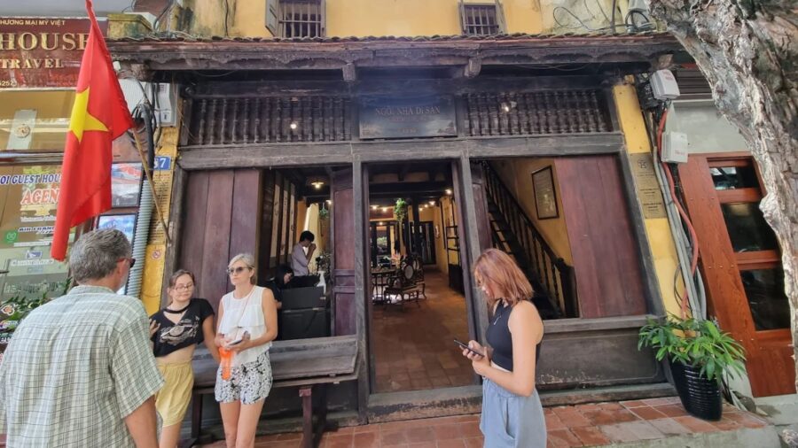 Exterior view of the classic architecture of a hanoi ancient house shaded by a tree