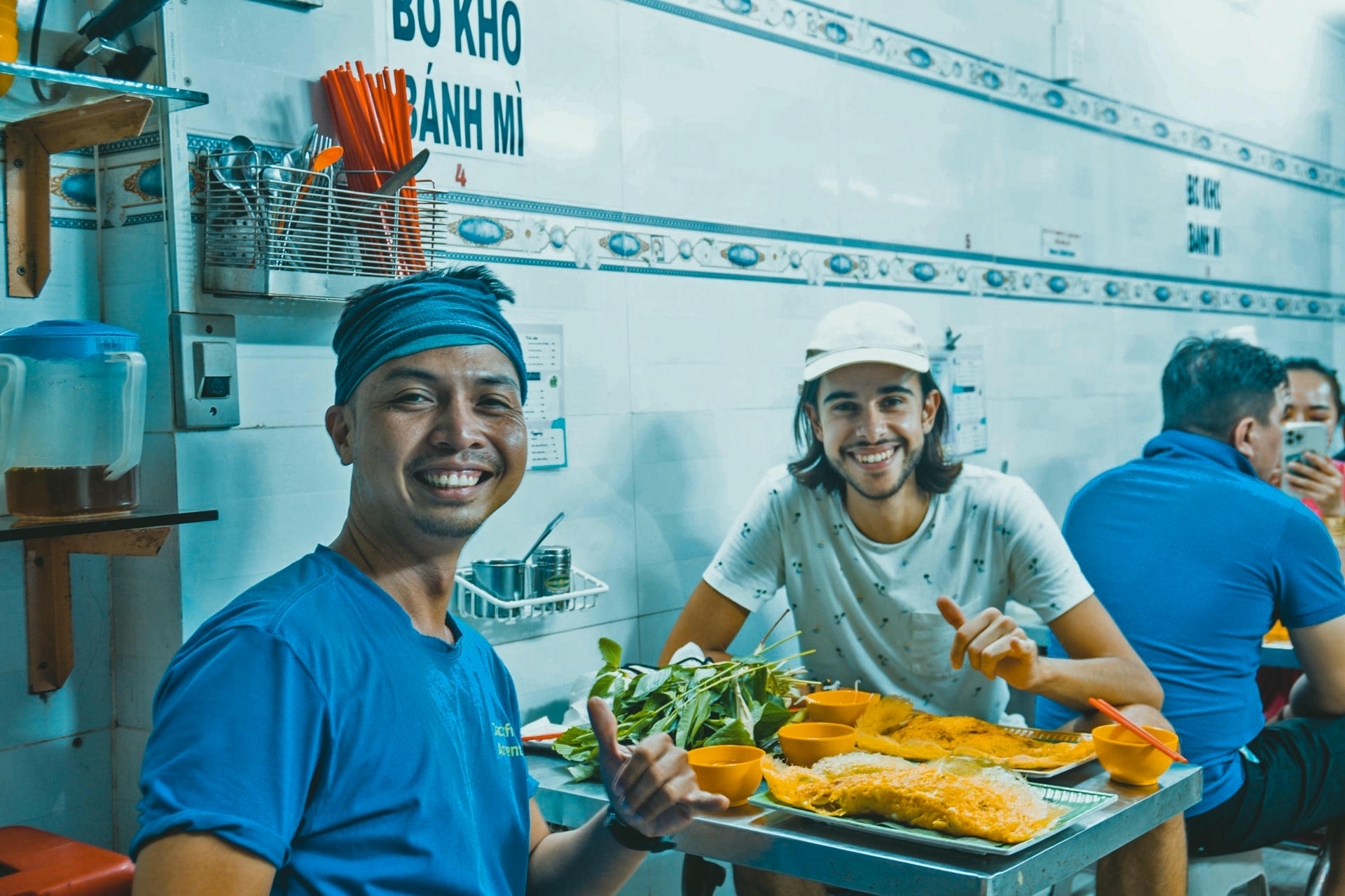 Tourists eating best banh xeo in Saigon with Jackfruit Adventure local tour guide