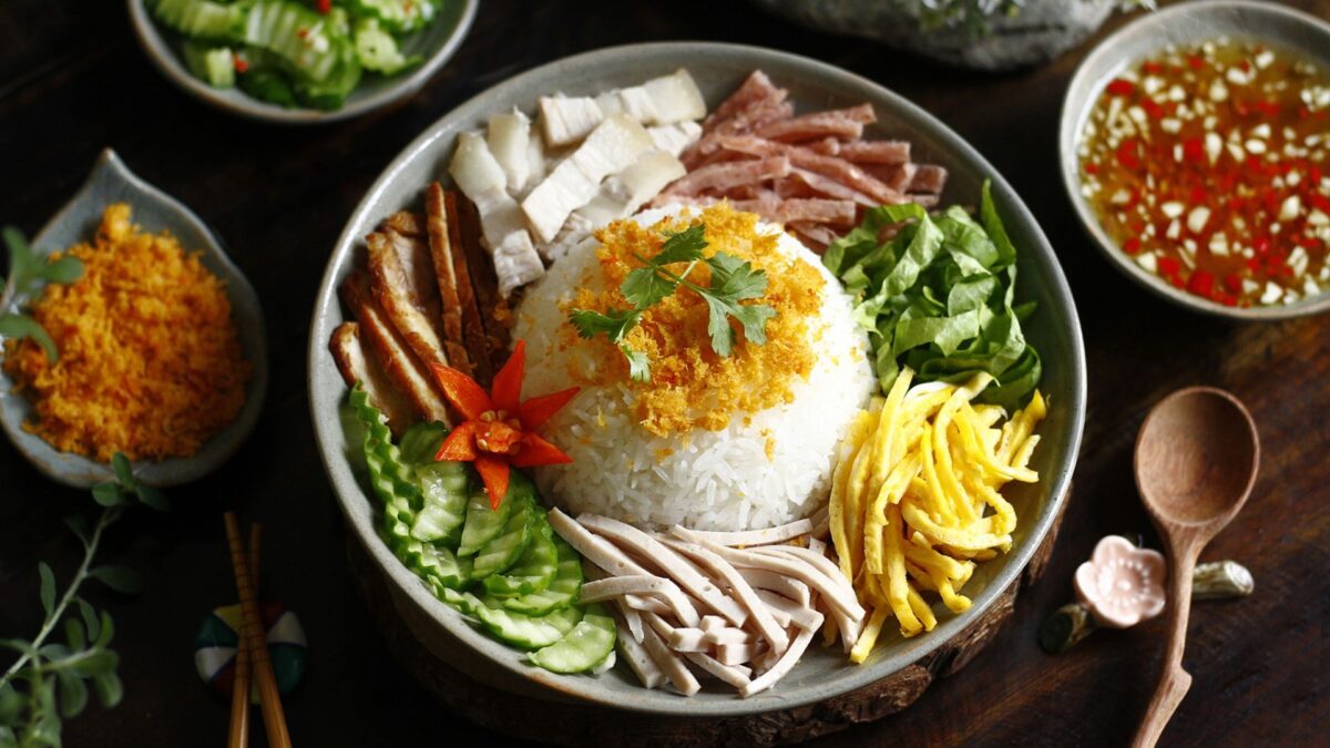 cơm âm phủ with rice, grilled pork, egg, herbs, pickles, and vegetables - hue food - Jackfruit
