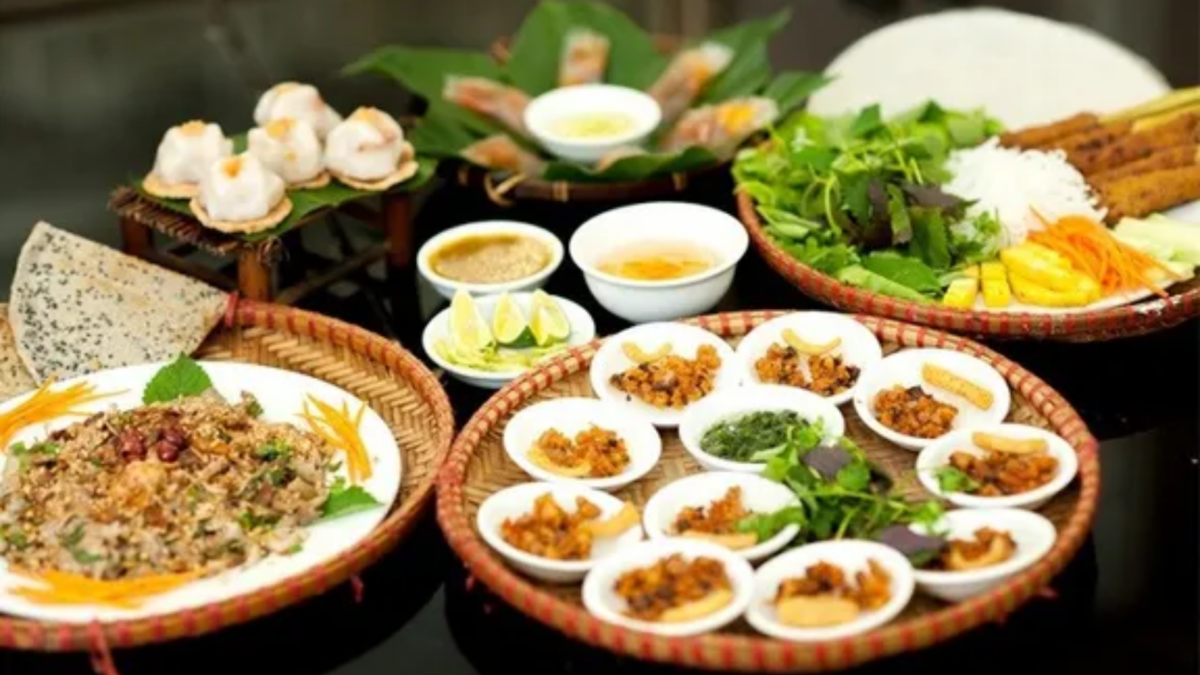 Traditional Hue food in Saigon featuring Bun Bo Hue, Nem Lui, Banh Beo, Banh Bot Loc, Com Hen, and fresh herbs served at a local Hue restaurant